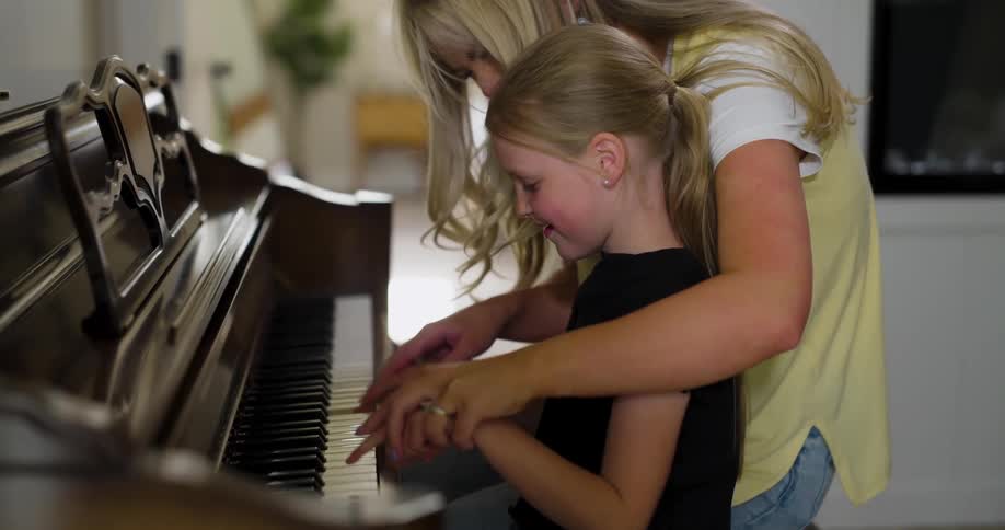 Mother and daughter playing piano together