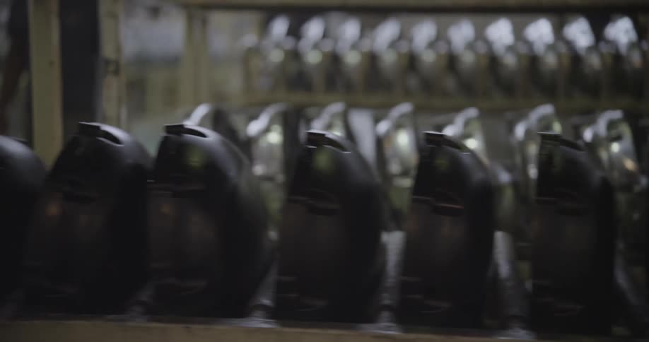 Metal pieces sitting on shelves in a factory as a person walks by