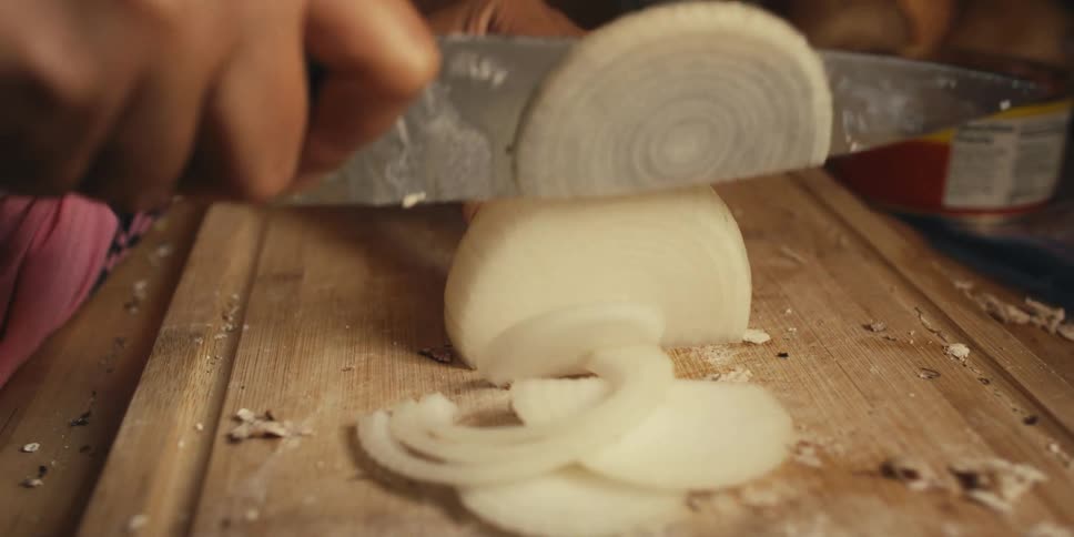 A person is slicing an onion
