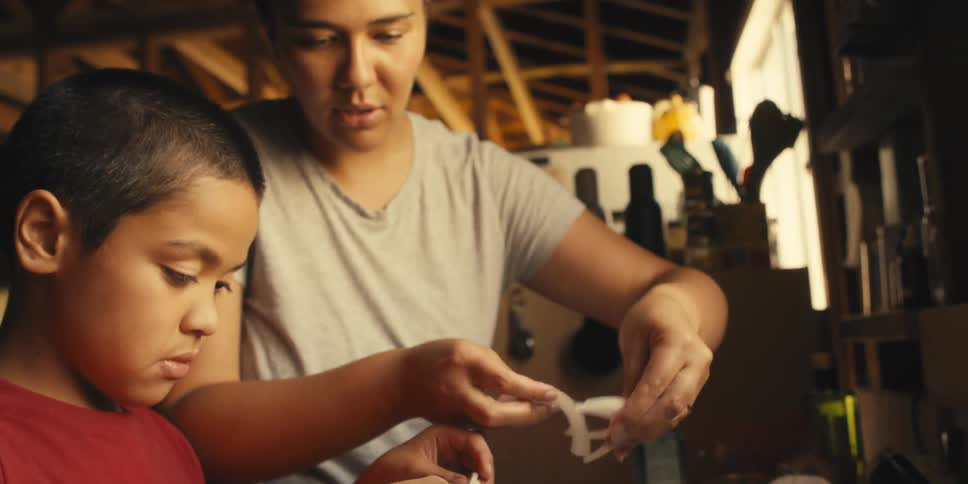 Mother and son together preparing food and shredding food and pouring it into a bowl