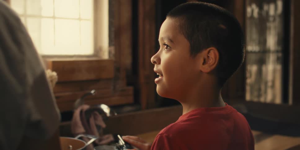 Portrait of a boy next to a person in the kitchen