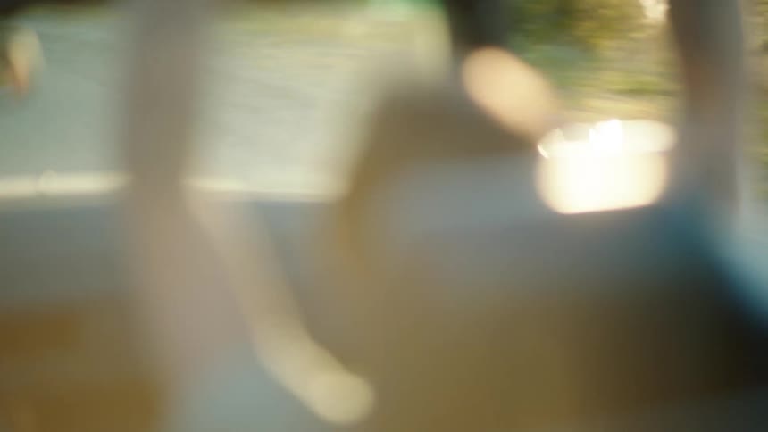 A seat with a person that is blurred and the person is inside a moving vehicle next to a window