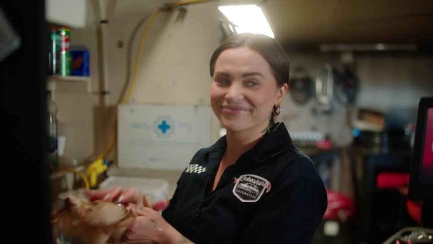 Smiling woman in a workshop drying her hands
