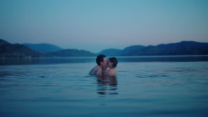 Man and woman in a lake kissing