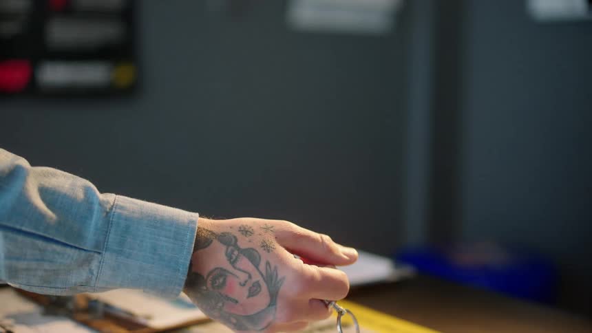 Hand handing over a key and a blank letter to another person