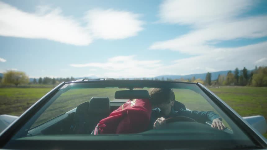 A couple drive down a road