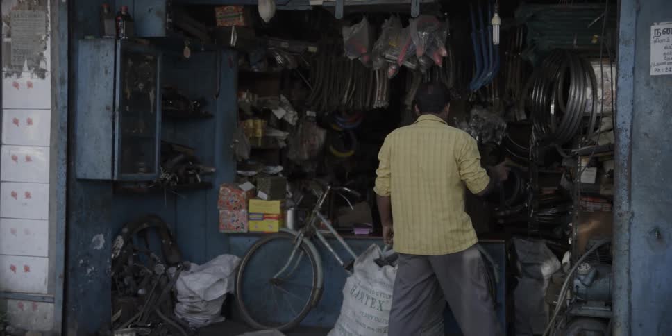 Man taking off helmet in cluttered garage