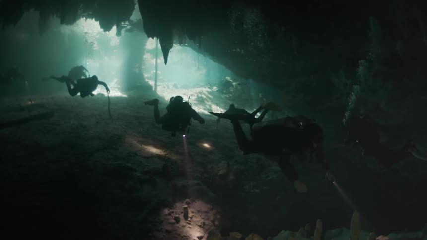 Three divers are in an underwater cave