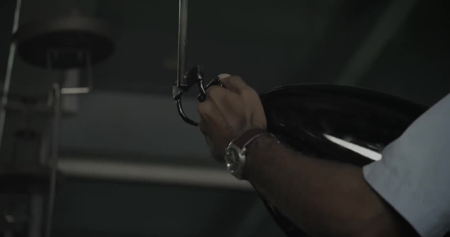 A man hangs an object on a metal hook