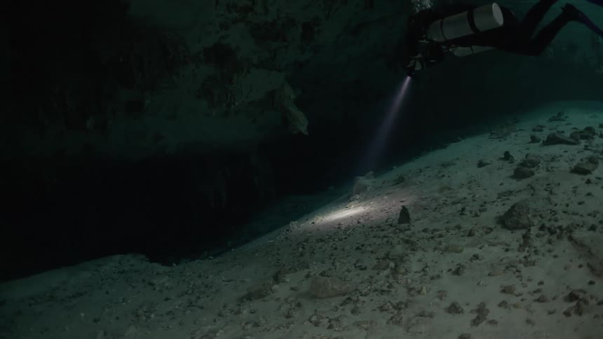 Adventurous diver submerged in an ocean inside caves