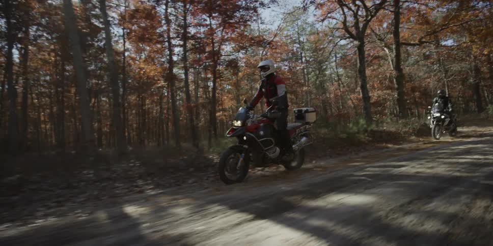 A man riding a motorcycle on a dirt road in the country