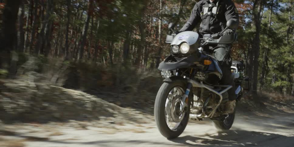 A man rides a motorcycle through a dirt path