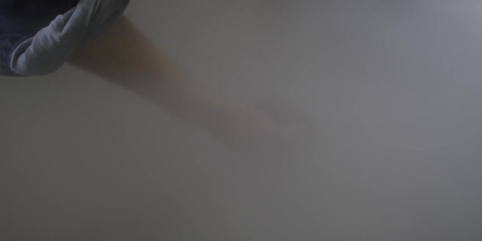 A man grabs objects out of a smoky area