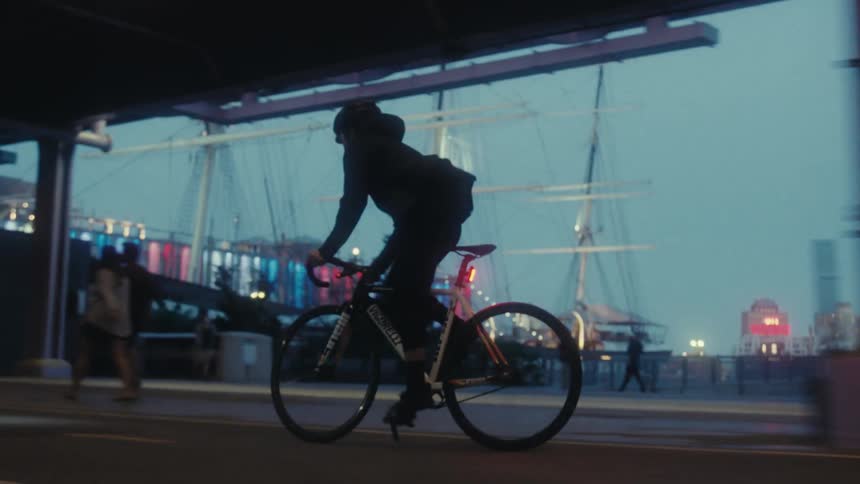 A man rides past pedestrians and other bicyclists on a city road