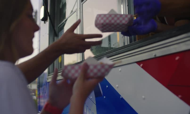 Two people get food from a trailer
