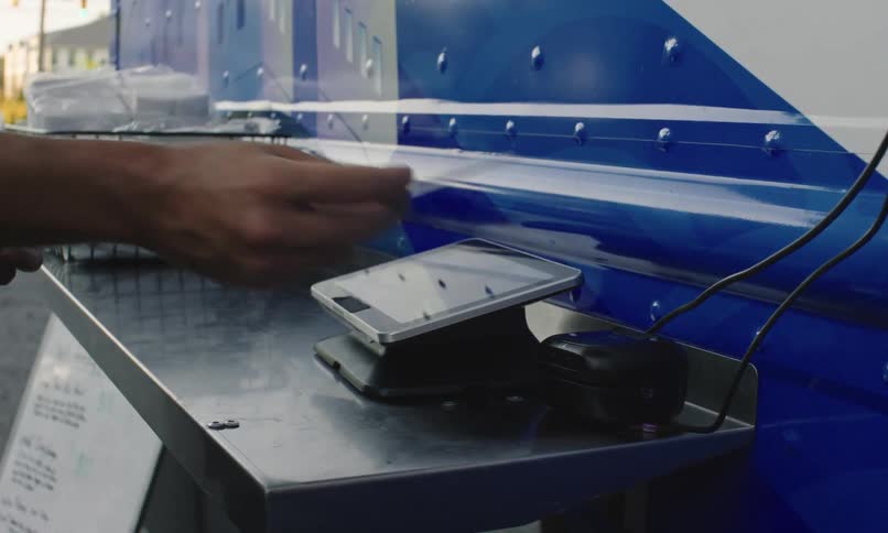Human hand places a card into an electronic device on a metal surface
