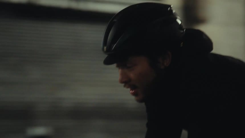 Closeup of a cyclist wearing a helmet and riding at night
