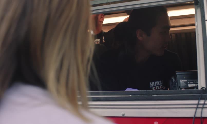 Man inside a food truck talking to a woman
