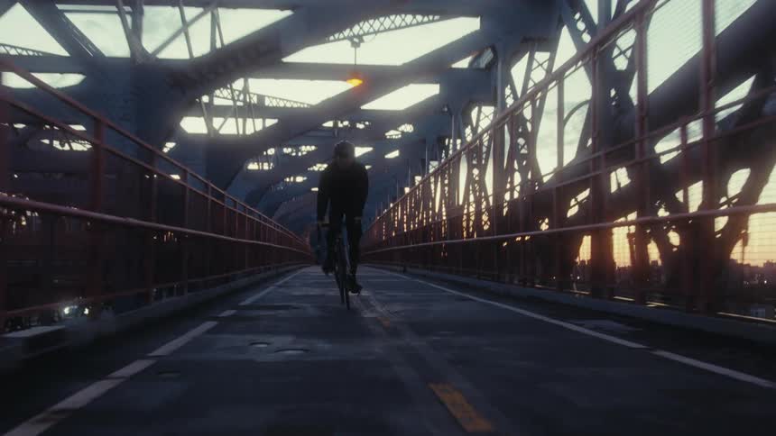 People crossing a large city bridge on bicycles