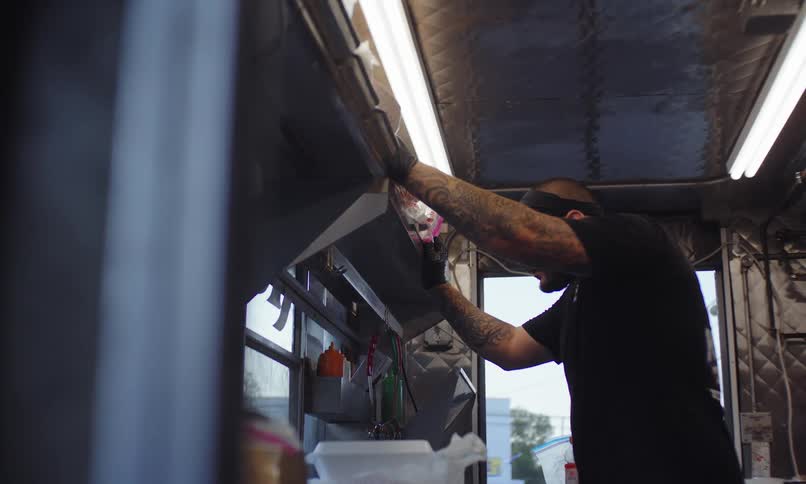 Man in apron working inside a food truck