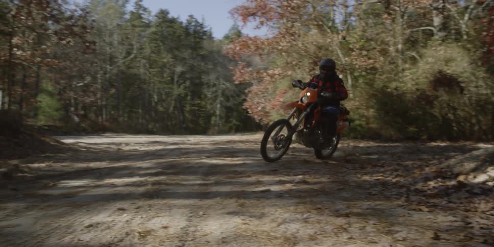 A man rides a motorcycle on a dirt road