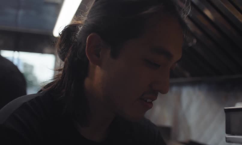 Side portrait of a young man inside an industrial kitchen