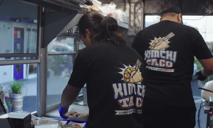 Two men inside a food truck cooking