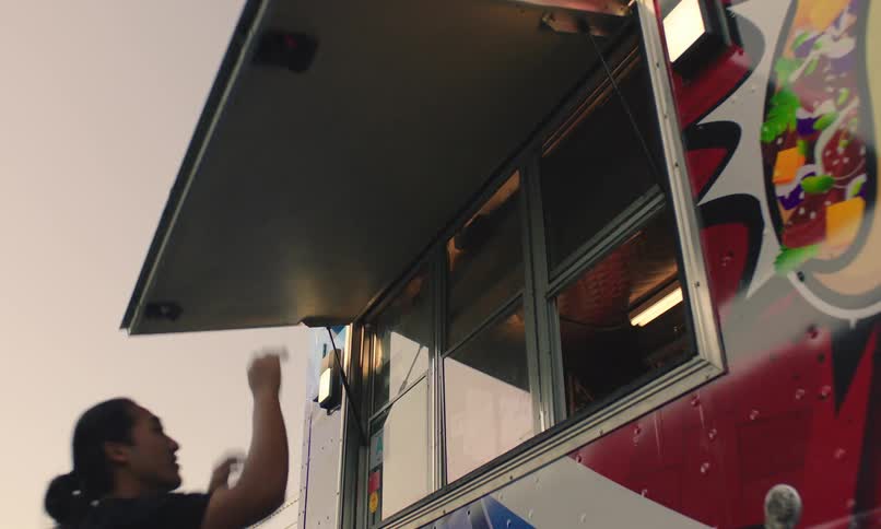 Man opening the window door of a food truck