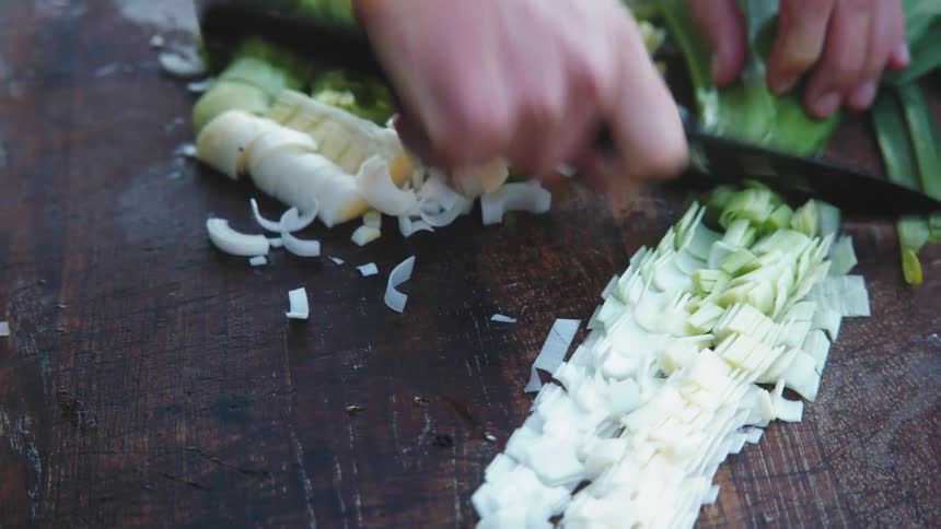 A person is cutting greens with a knife