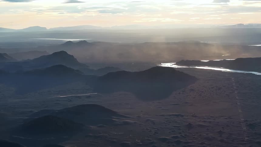 Panorama of a river winding through desert mountains on a cloudy day