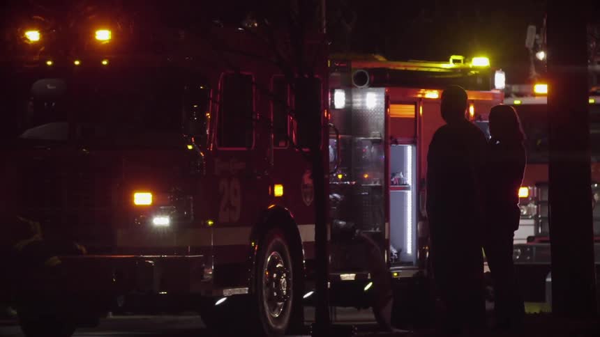 A firetruck flashes its lights at night