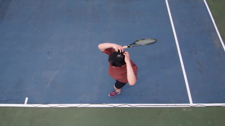 Young man running towards the ball on the court and putting his hands on his head while holding a tennis racket