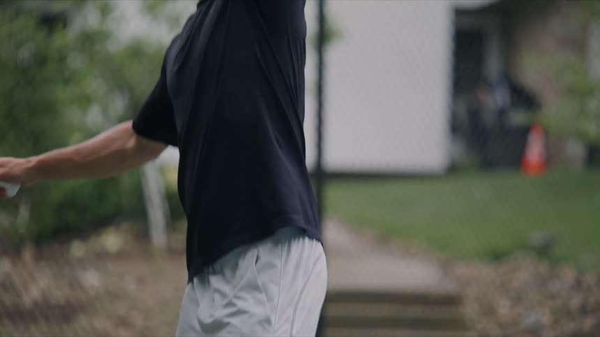Young man throwing a ball with a tennis racket