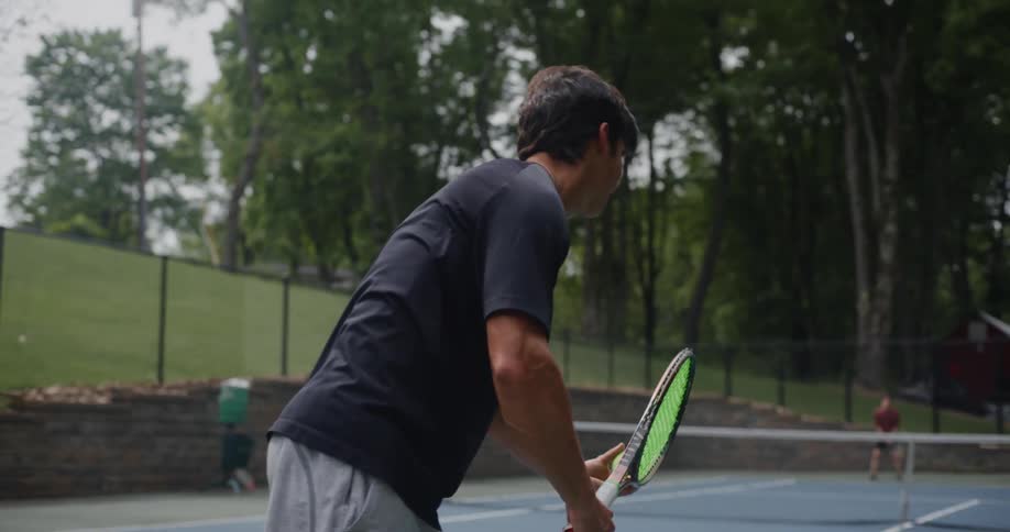 A man serves a tennis ball to his opponent