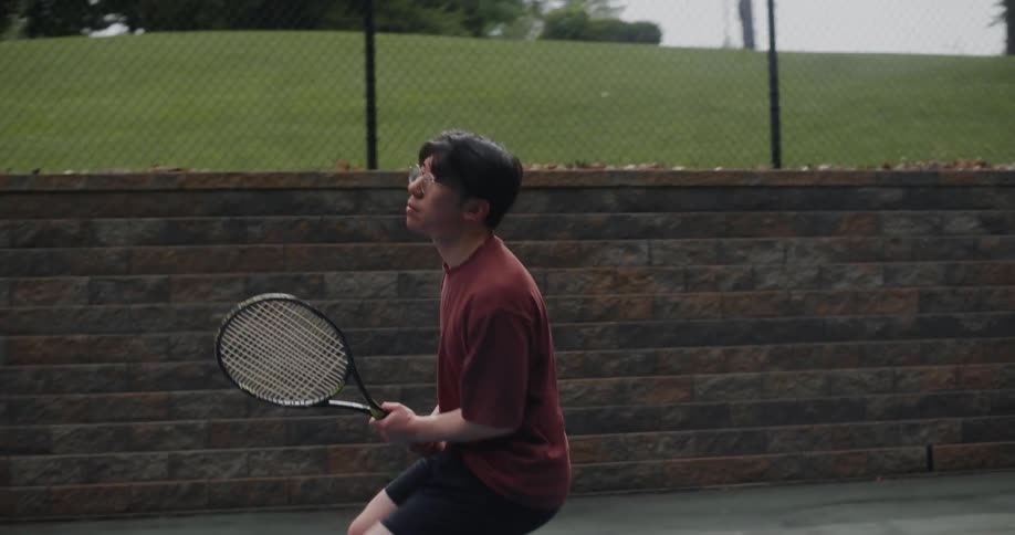 A man swings a tennis racket hitting a tennis ball
