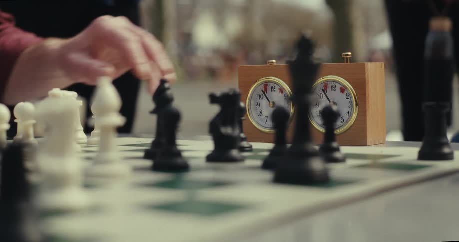 Two people playing chess and pausing time
