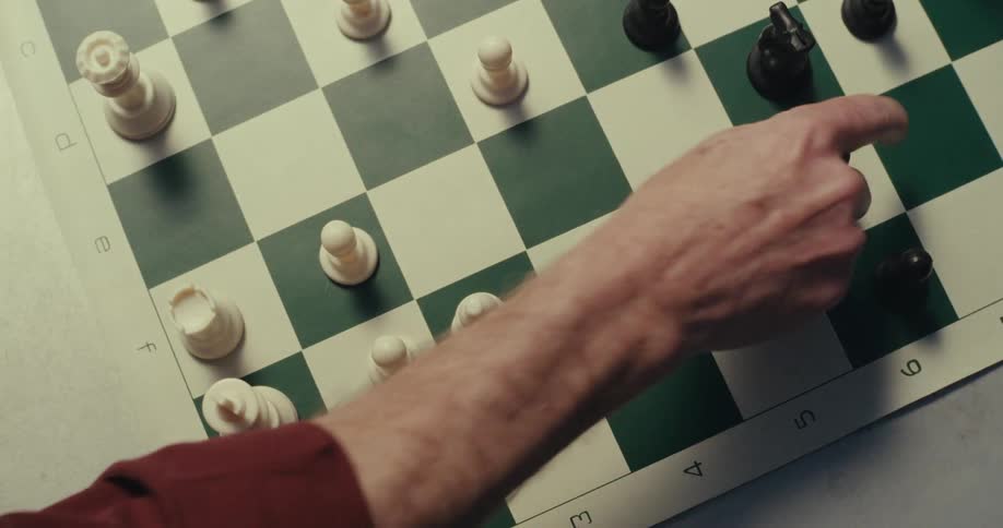 A man moves a chess piece