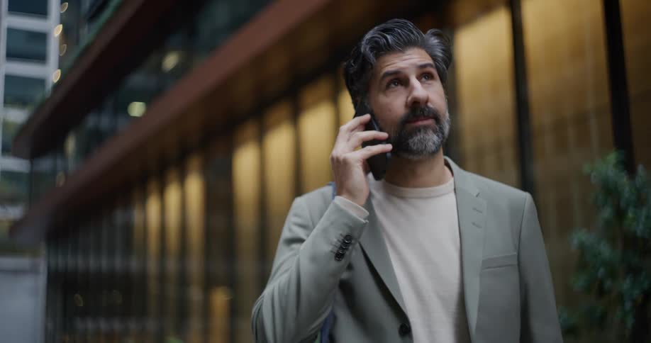 Man in a suit picking up his cell phone and answering a phone call