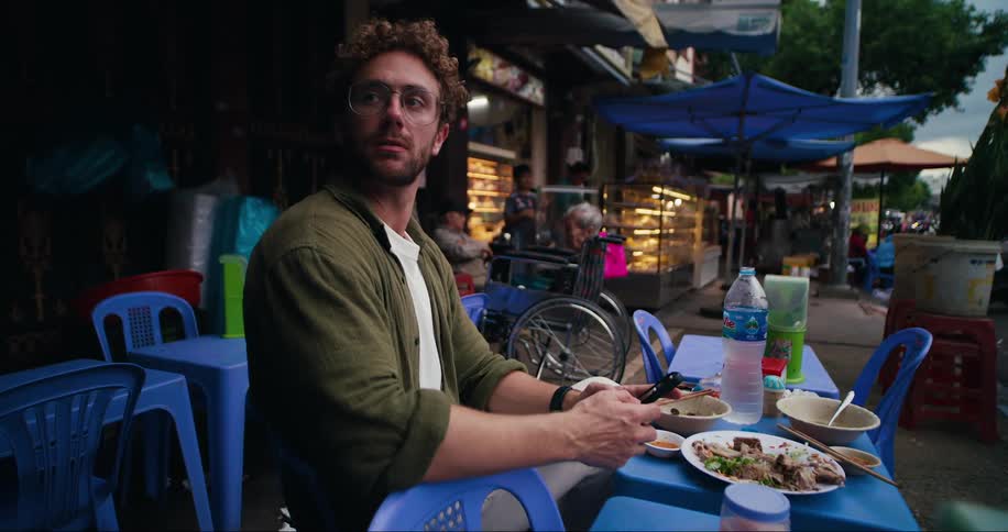 A man is eating outdoors at the restaurant