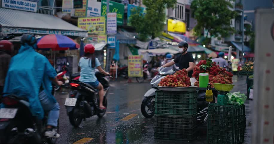A busy street with people riding mopeds