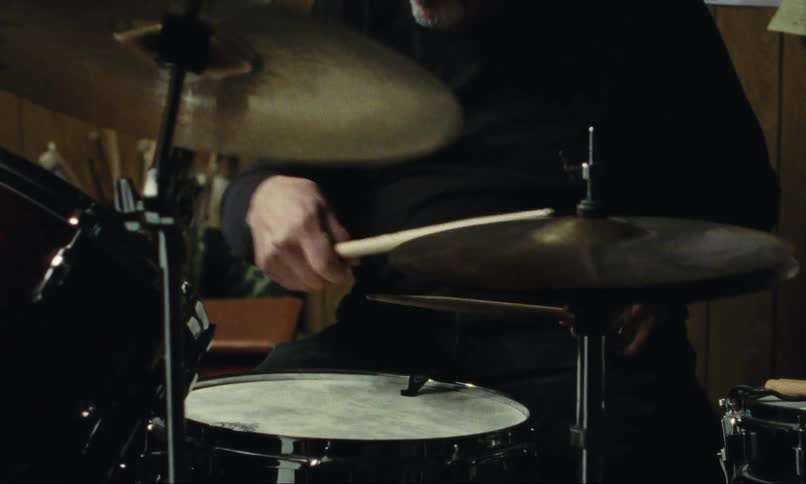 man plays drums in basement