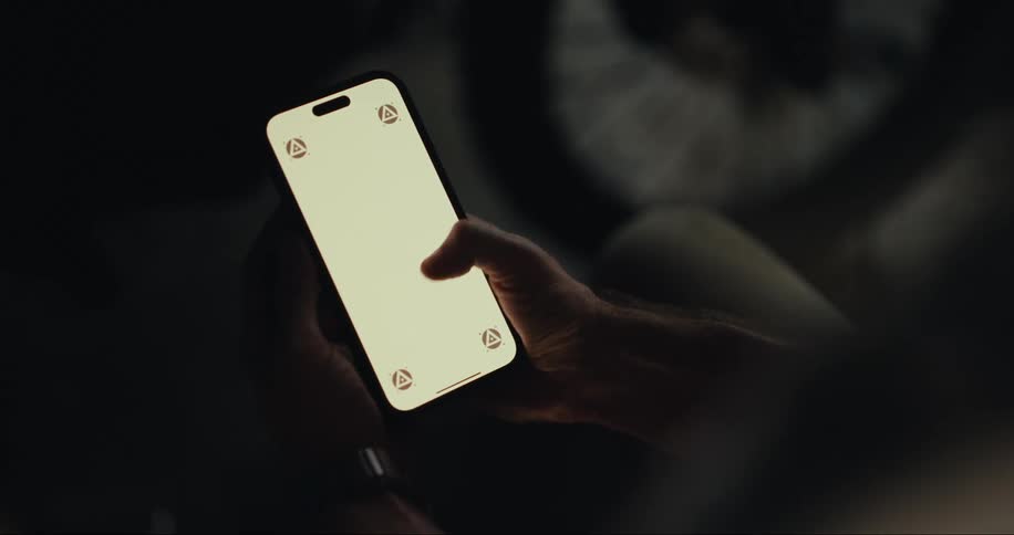 A white male taps his smartphone several times
