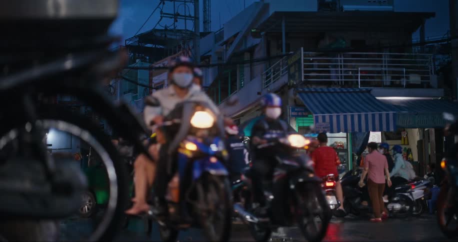 People on motorcycles and scooters driving on the same streets as taxis