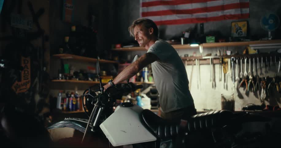 A man working on a motorcycle in a dimly lit garage