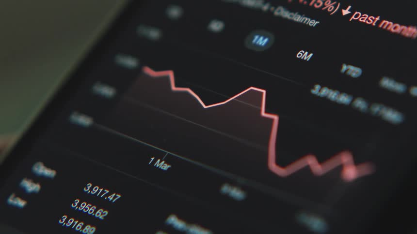 A person scrolls through stock market data on their phone