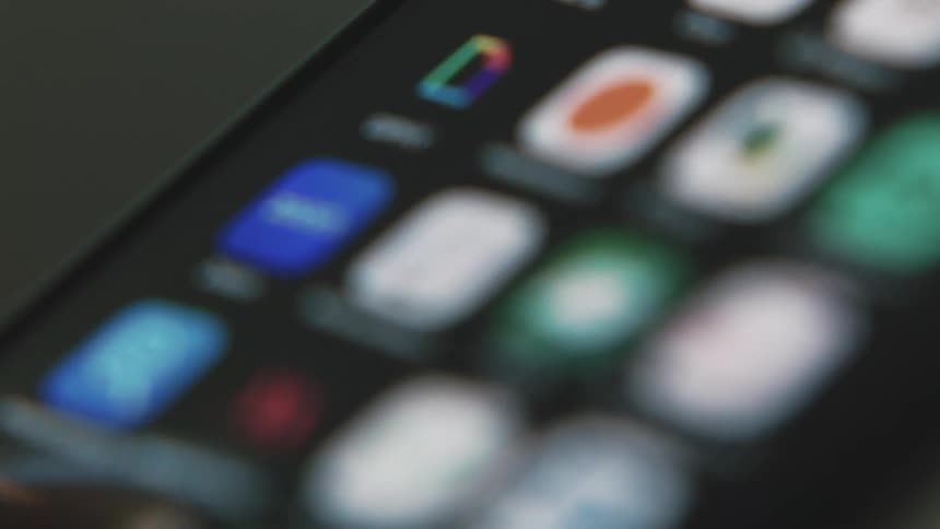 Someones barely visible finger swipes right several times on a smartphone showing all of their apps
