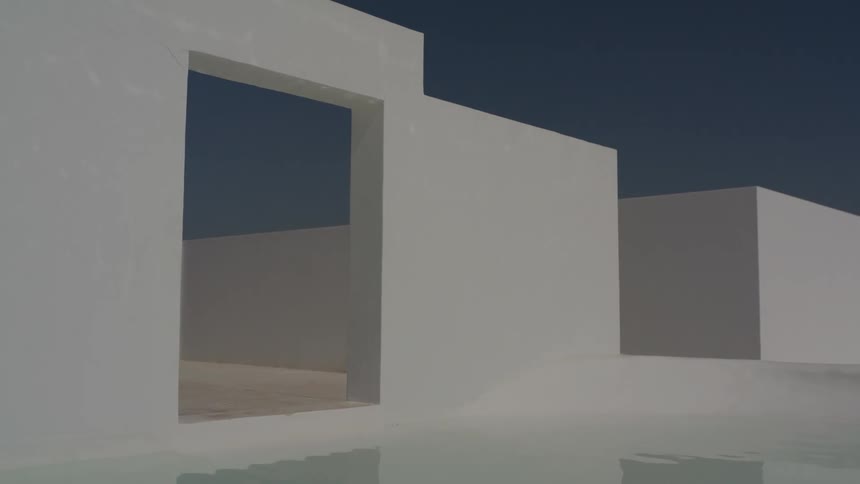 A white wall with square holes and below a pool of water