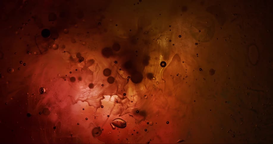 A viscous liquid of red and orange color with some bubbles and movements