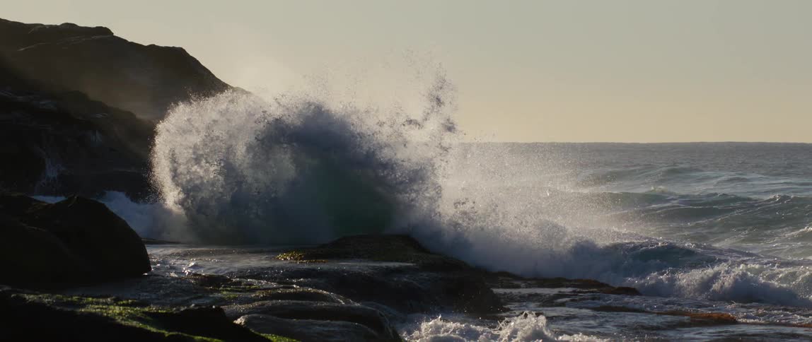 Foamy wave hitting rocks with force and pressure