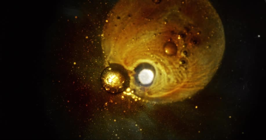 Small and large amber bubbles float in a yellow brown liquid